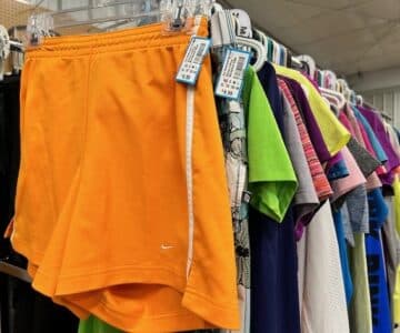 Women's active wear bottoms. Bright orange Nike sport shorts in front.